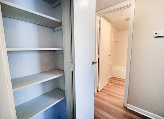 A white refrigerator with four shelves is open.