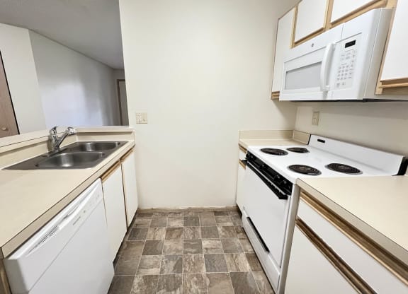 a kitchen with white appliances and a sink and a stove at Eagle Crest Apartments, Galloway, Ohio