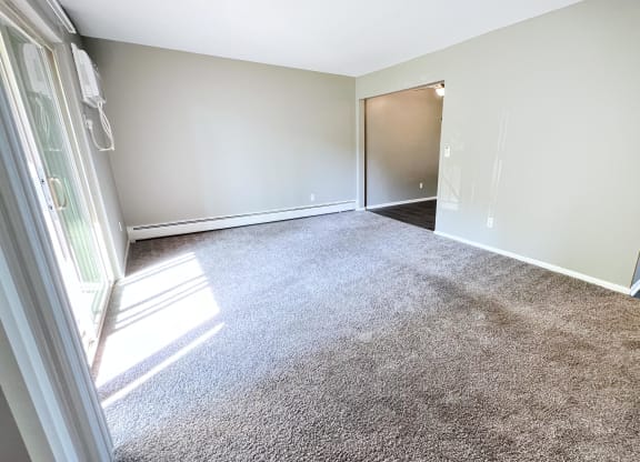 an empty living room with carpet and a door to a bedroom at Crown Pointe Apartments, Kentucky, 41014