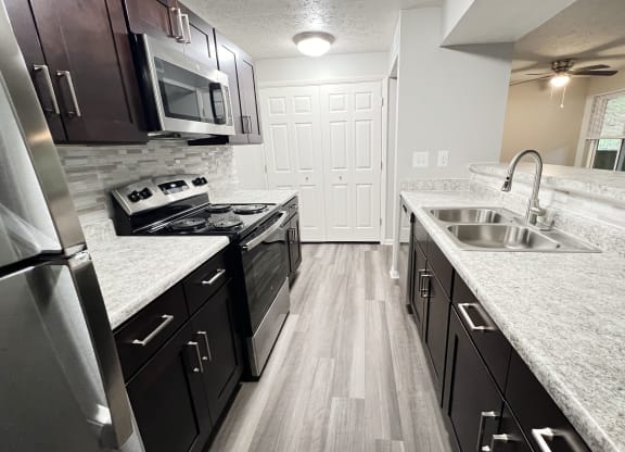 a kitchen with granite counter tops and stainless steel appliances at The Vinings Apartments, Cincinnati, Ohio