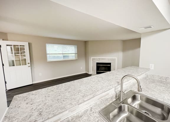 an empty kitchen with a sink and a fireplace at The Vinings Apartments, Cincinnati