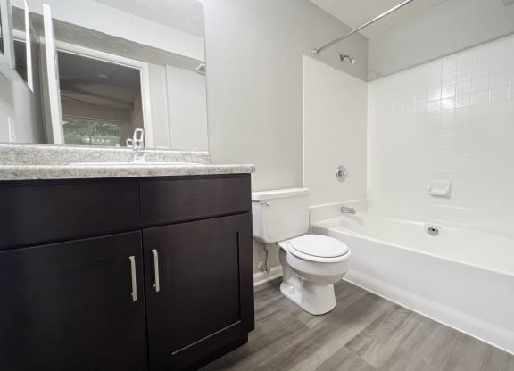 a bathroom with a toilet and a tub and a sink at The Vinings Apartments, Cincinnati, 45245