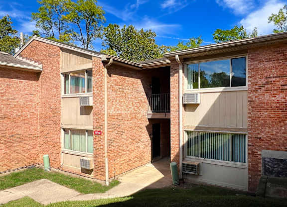 A brick building with a balcony and a door.