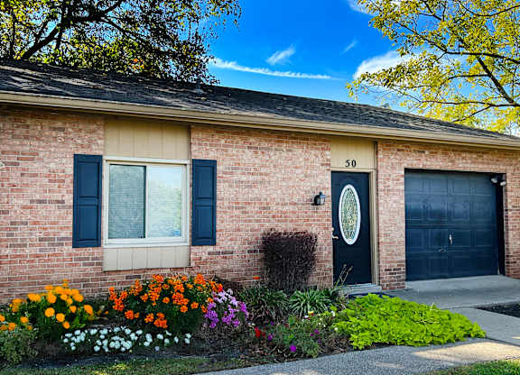 A house with a black door and a window with black shutters.