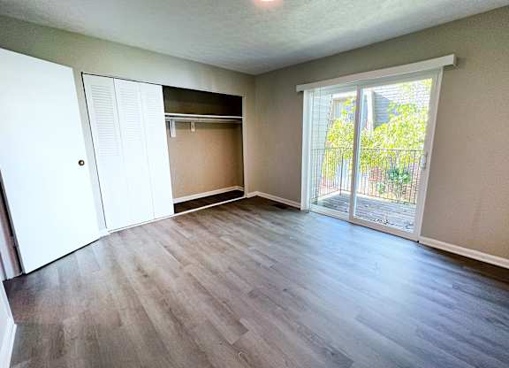 A room with a sliding glass door leading to a backyard.