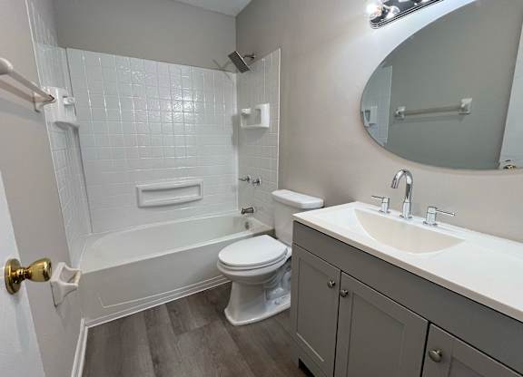 A white bathroom with a toilet, sink, and bathtub.