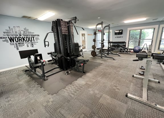 a gym with weights and other equipment in a building with windows at Deercross Apartments, Cincinnati, 45236