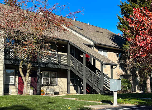 A house with a red door and a tree with red leaves.