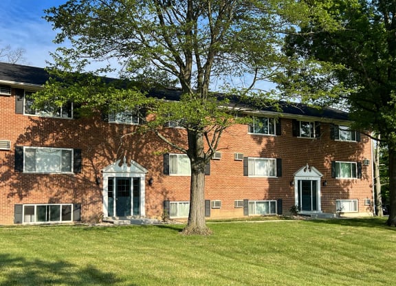 a red brick house with a tree in front of it at Sharondale Woods Apartments, Cincinnati, OH