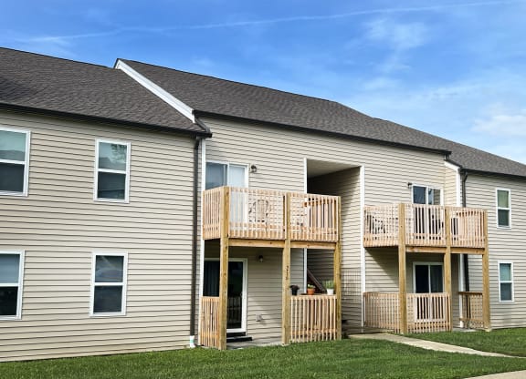 the back of a house with a balcony and a yard at 450 on Keeneland Apartments, Richmond, KY 40475