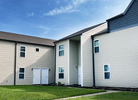 a row of houses with white siding and a grass yard at 450 on Keeneland Apartments, Richmond, KY 40475