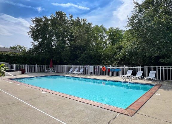 a swimming pool with chairs and a fence around it at 450 on Keeneland Apartments, Richmond, KY 40475
