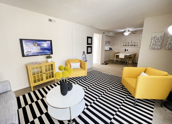 a living room with yellow furniture and a black and white rug at Miamisburg by the Mall, Miamisburg