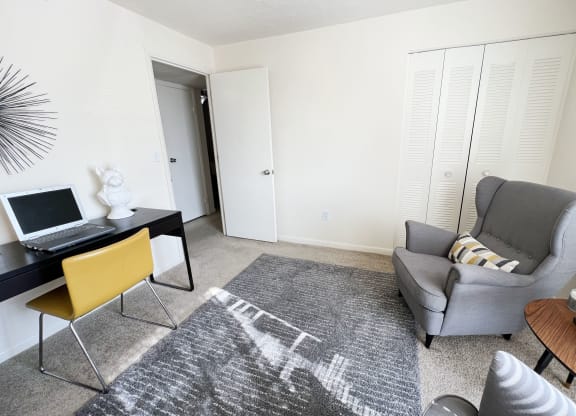 a living room with a chair and a desk with a laptop at Miamisburg by the Mall, Miamisburg, OH, 45342