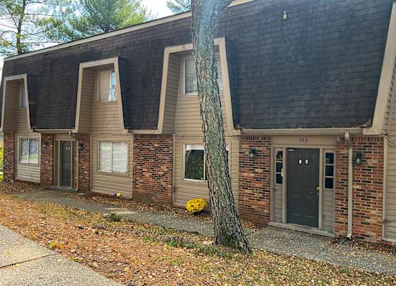 the front of a brick house with a black door
