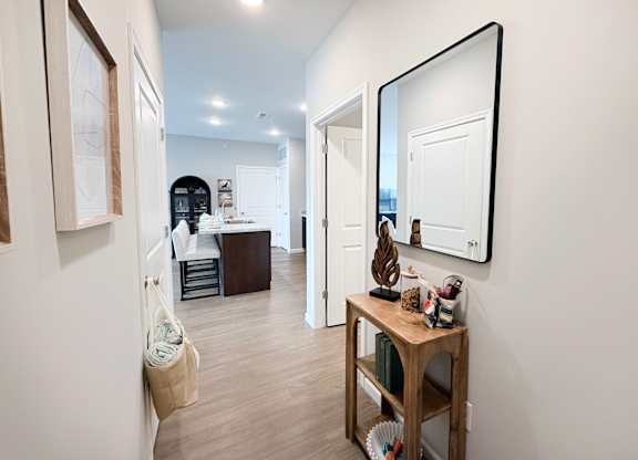 A hallway with a wooden table and a mirror on the wall.