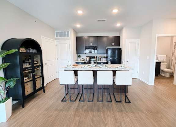 A modern kitchen with a dining table and chairs.