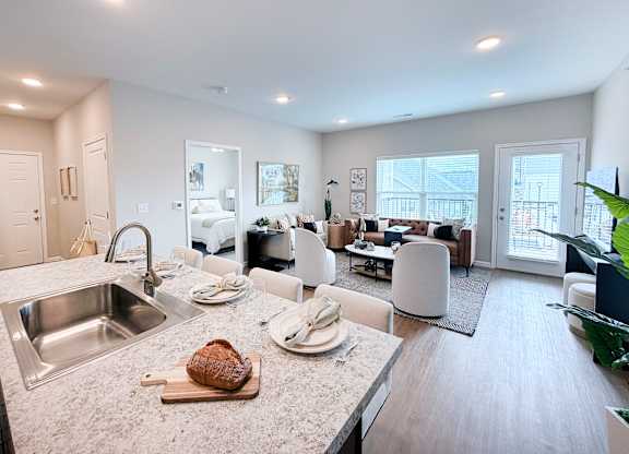 A modern kitchen with a large island and a dining area.