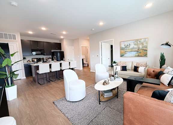A modern living room with a brown sofa and a grey rug.