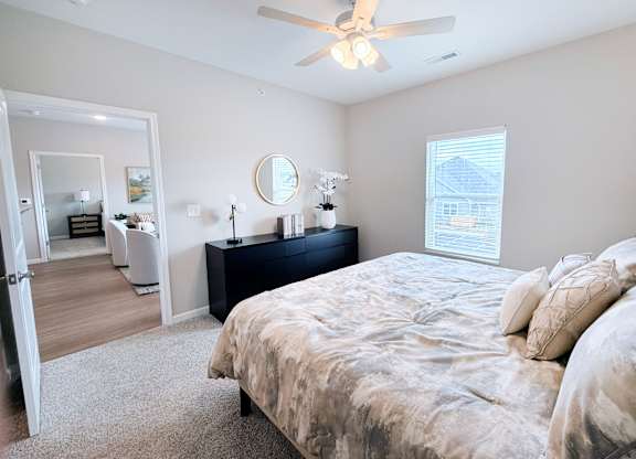 A bedroom with a large bed and a ceiling fan.
