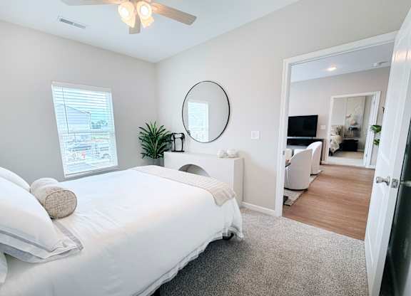 A bedroom with a large bed and a ceiling fan.