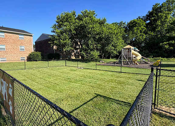 A playground with a slide and a fence in the foreground.