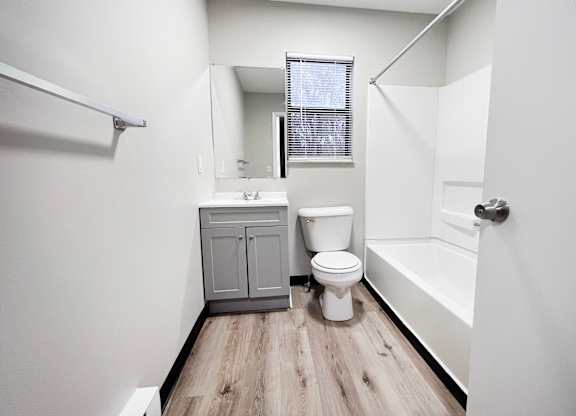 A white bathroom with a toilet, sink, and bathtub.