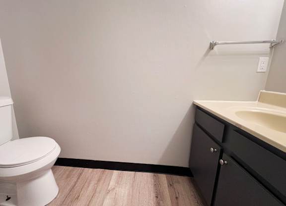 A white toilet sits next to a sink in a bathroom.