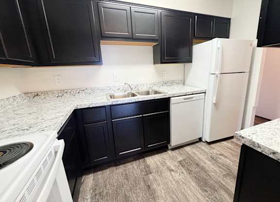 an empty kitchen with white appliances and black cabinets at Indian Lookout Apartments, Cincinnati, 45238