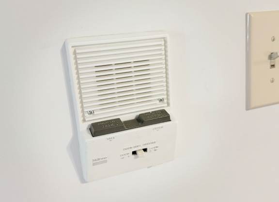A wall-mounted air conditioner unit with a remote control.