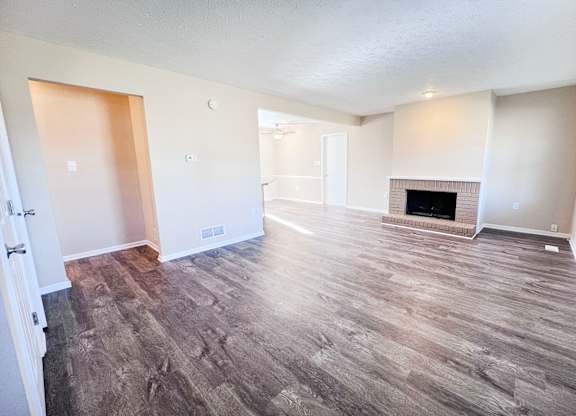 A room with a fireplace and wood flooring.