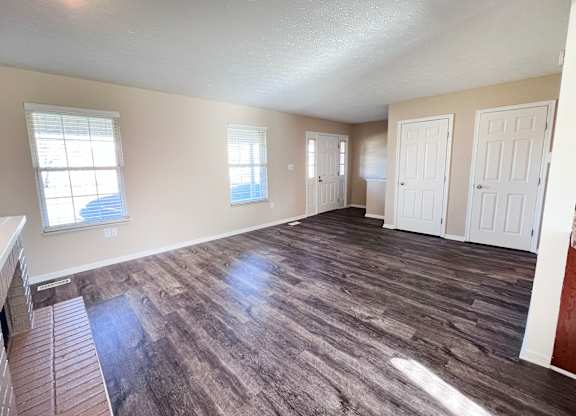 A room with wood flooring and white walls.