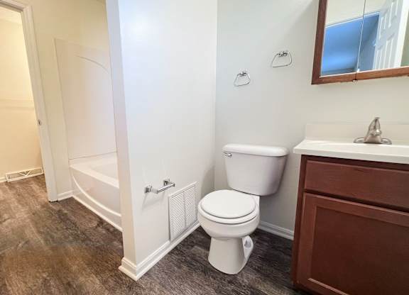A white toilet sits next to a sink in a bathroom.
