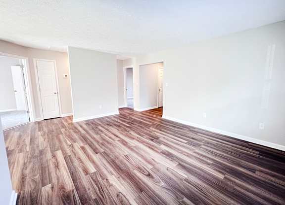 A room with wooden flooring and white walls.