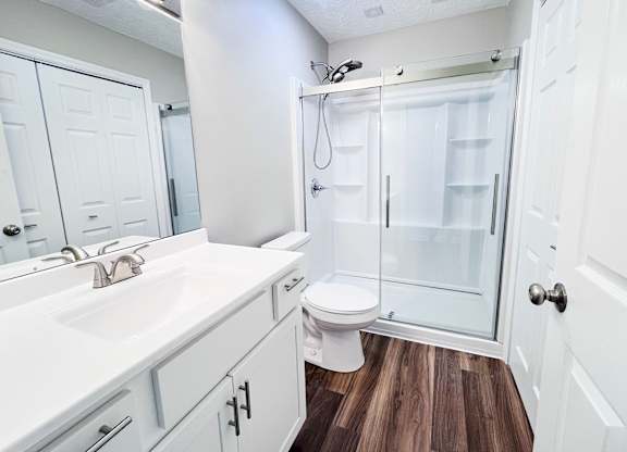 A white bathroom with a walk in shower.