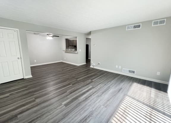 an empty living room with wood flooring and a white door at Fox Run Apartments, Cincinnati