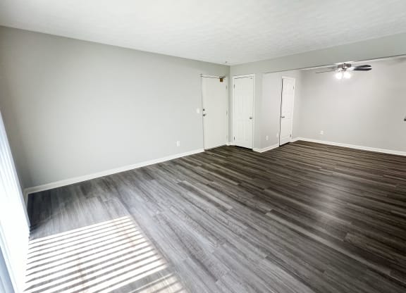 an empty living room with wood floors and white walls at Fox Run Apartments, Cincinnati