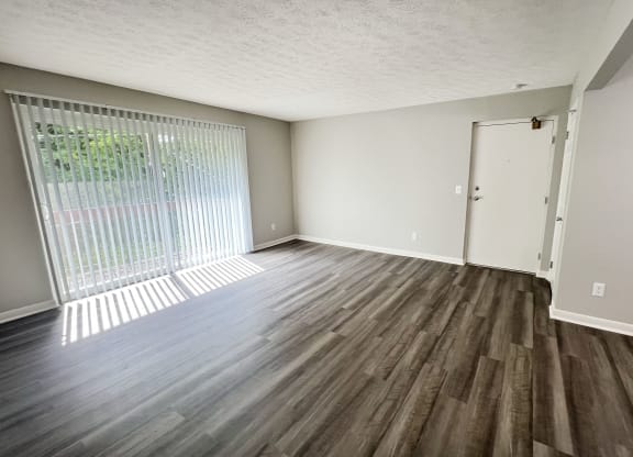 an empty living room with wood flooring and a window at Fox Run Apartments, Cincinnati