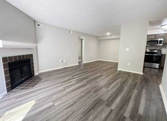 a living room with a fireplace and wooden floors at Deercross Apartments, Cincinnati, OH 45236