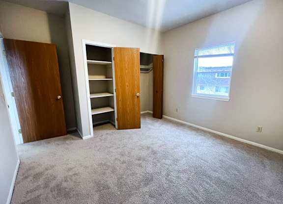 A room with a carpeted floor and a window.