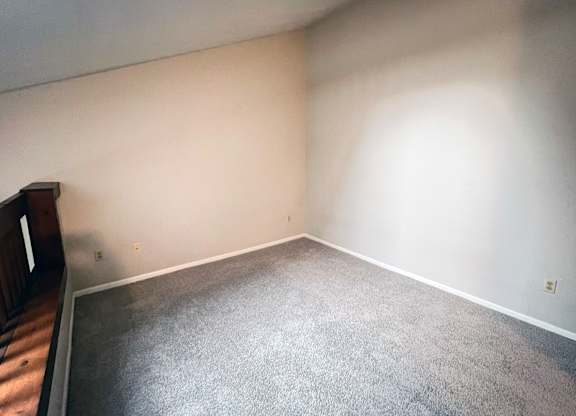 A room with a grey carpet and white walls.