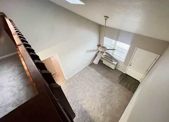 A room with a ceiling fan and a door.