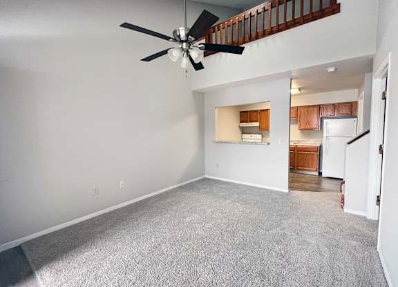 A room with a ceiling fan and a carpeted floor.