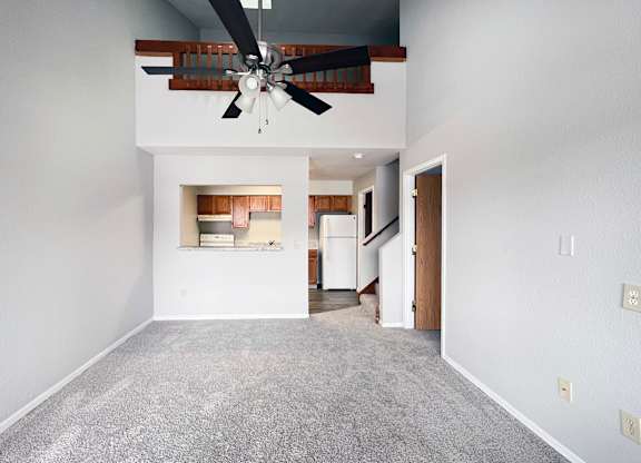 A room with a ceiling fan and a carpeted floor.