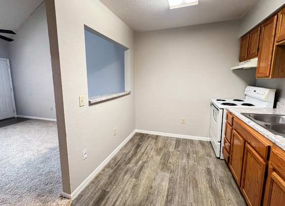 A kitchen area with a stove top oven and sink.