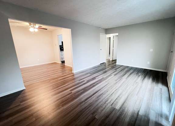 A room with wooden flooring and white walls.