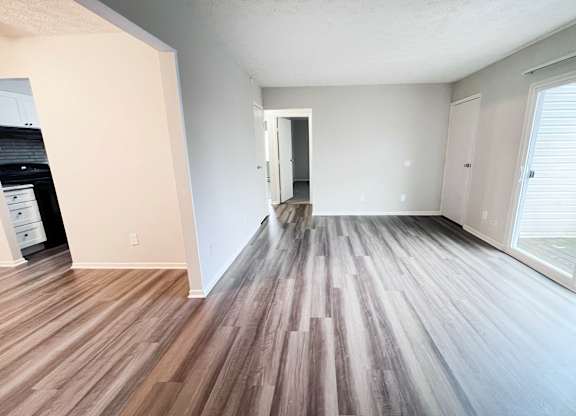 A room with wooden flooring and white walls.