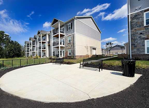 A modern apartment complex with a circular courtyard in the foreground.