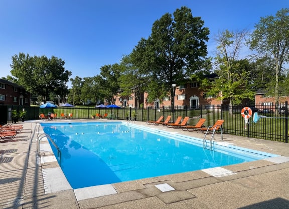 a swimming pool with chairs around it in front of a building at Sharondale Woods Apartments, Cincinnati, 45241