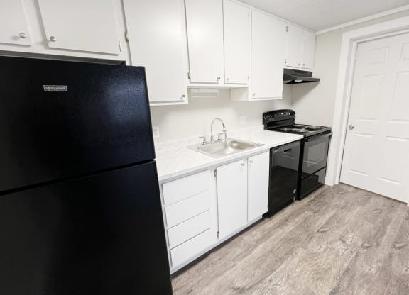 a kitchen with white cabinets and a black refrigerator  at Wentworth Estates Apartments, Florence, Kentucky